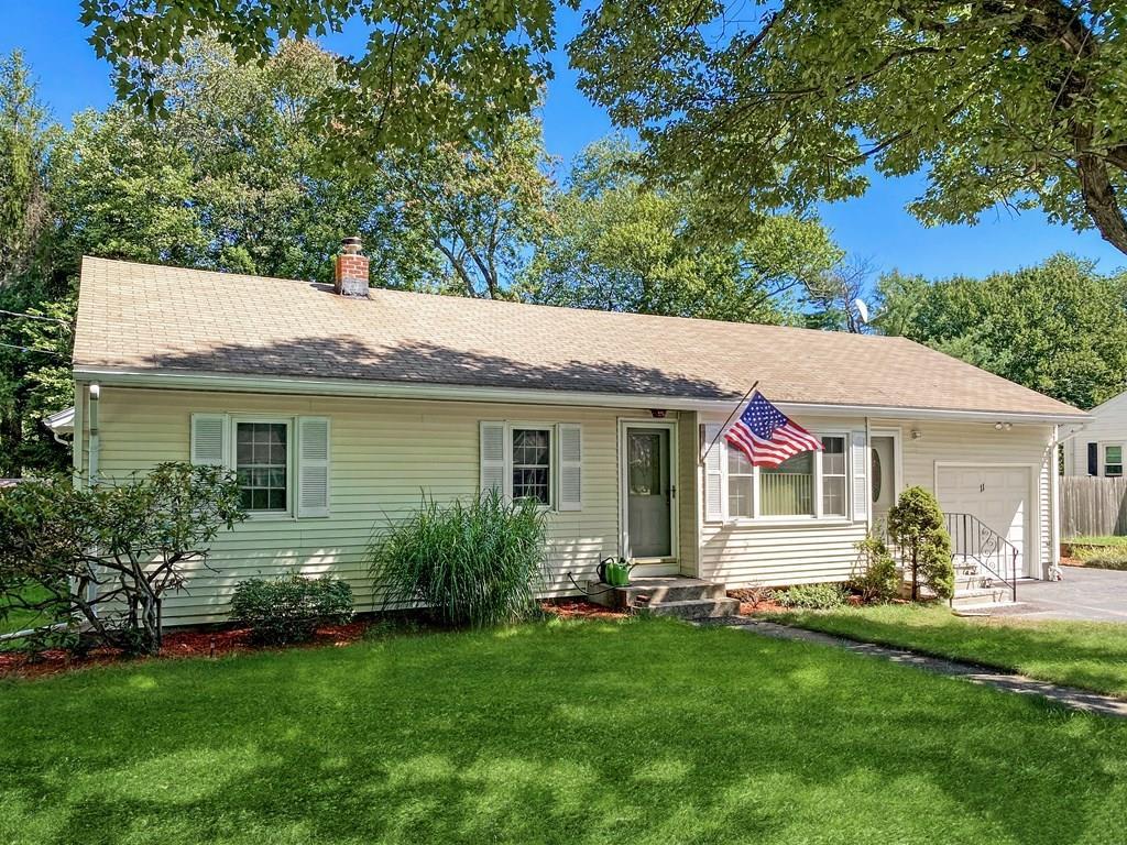 detached lilac colored contempory colonial style home surrounded by trees and lawn